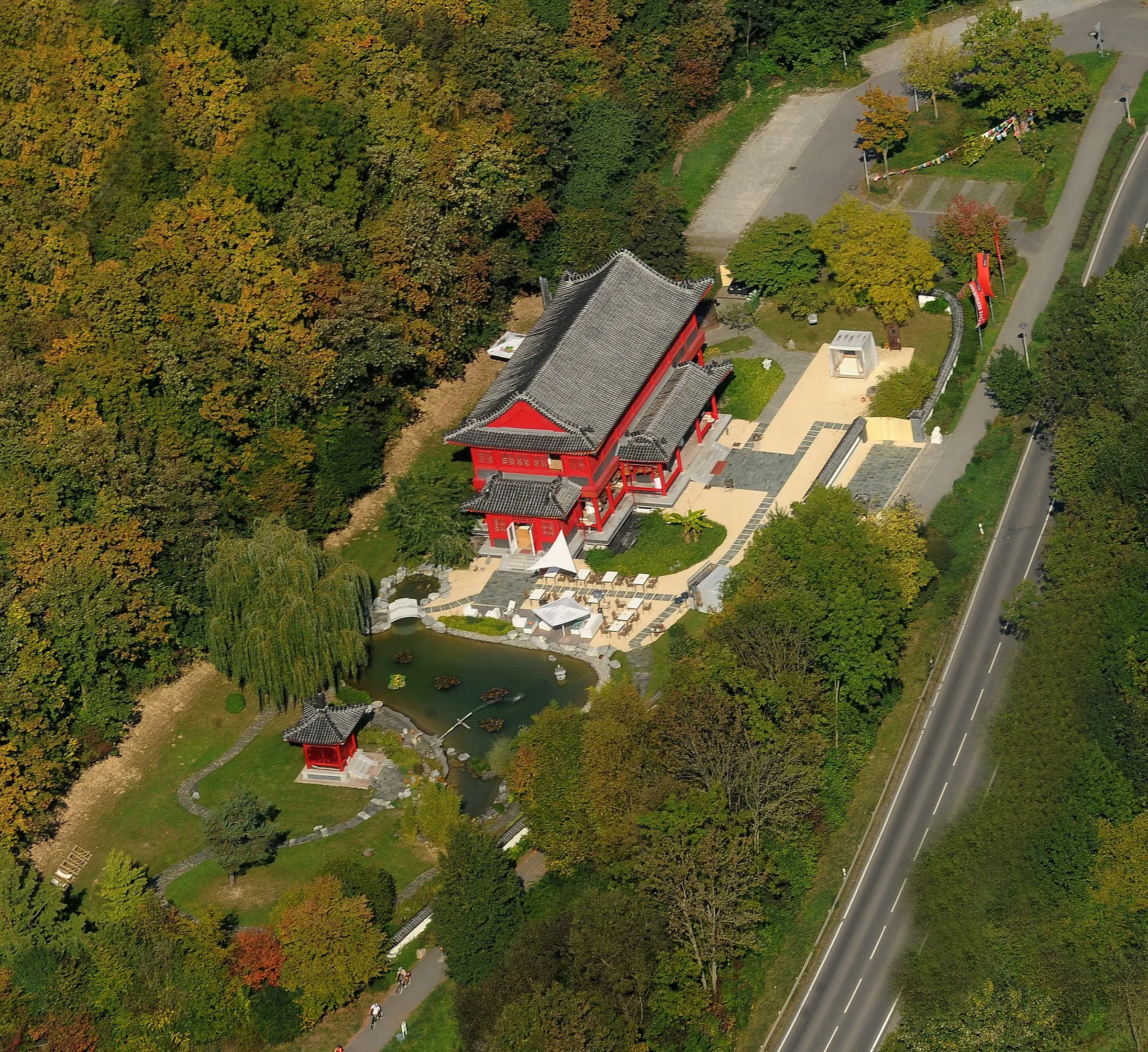 Luftbild des Ming China Center: die rote Pagode, der Teich mit Fontäne, der Pavillon und der Wald ringsum.