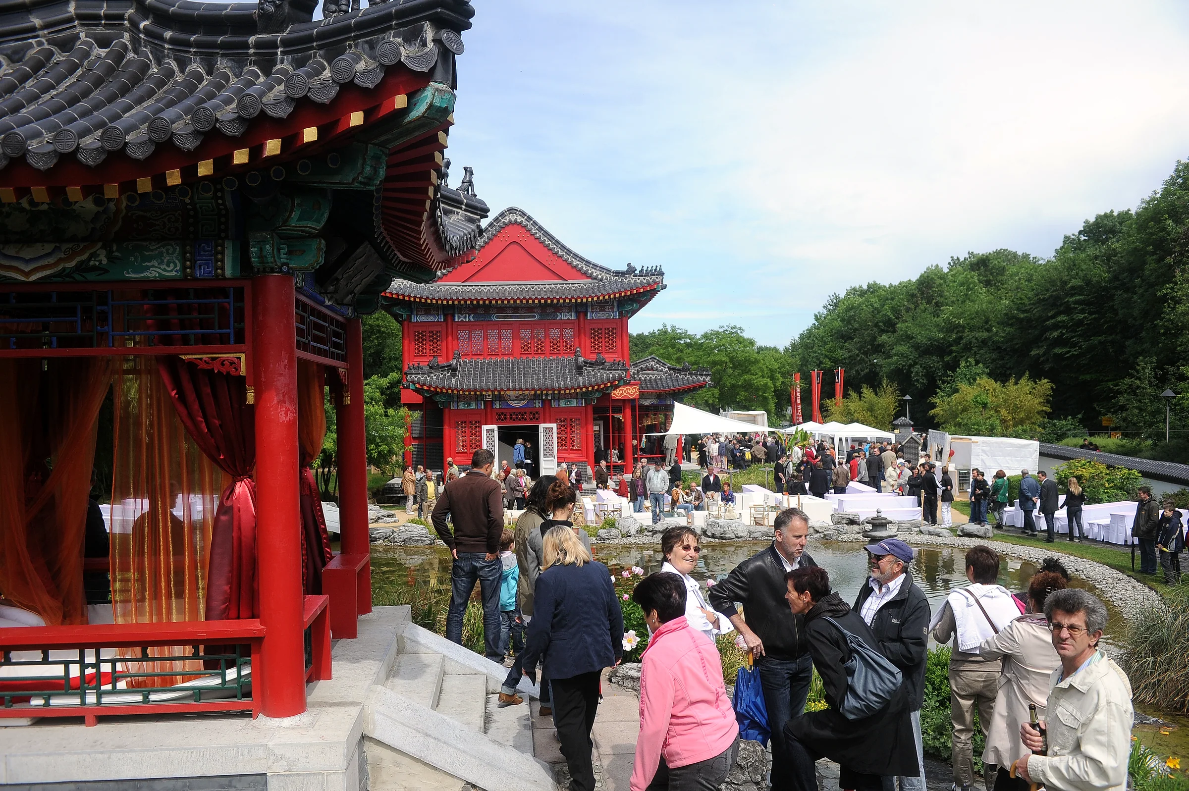 Fest im Garten des Ming China Center: das rote Pavillondach, dahinter die Pagode und weiße Zelte.